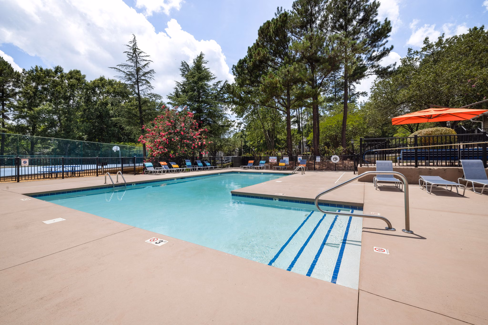 Resort-style pool with lounge chairs at Sunstone Apartments offering luxury living experiences