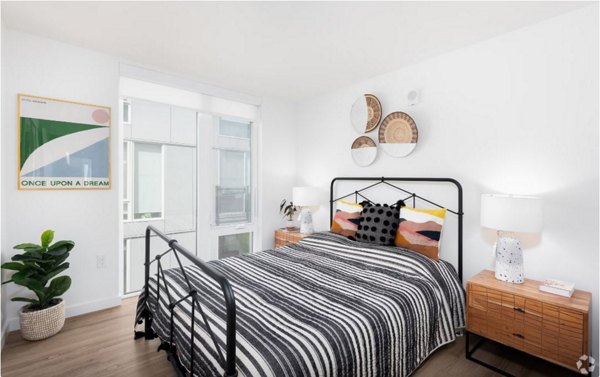 Elegant bedroom with modern furnishings in Arlo Apartments, featuring plush bedding and sleek design elements