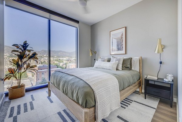 Modern bedroom with large windows at The Worthington Apartments, a Greystar luxury property