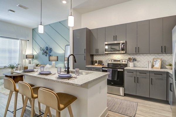 Modern kitchen with granite countertops and stainless-steel appliances in Solis Gainesville Apartments