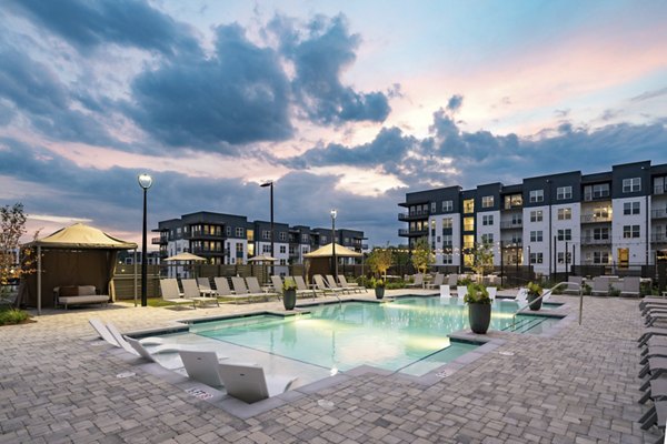 Modern pool area at Solis Gainesville Apartments featuring lounge chairs and greenery, offering a luxurious outdoor living experience