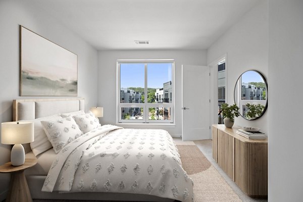 Cozy bedroom with large windows at Riverside Wilton Apartments offering luxury living features and a relaxing ambiance