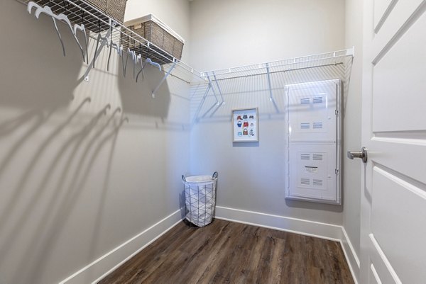 Walk-in closet with built-in shelves at Newbrook Point Hope Apartments - stylish storage solutions in luxury living spaces
