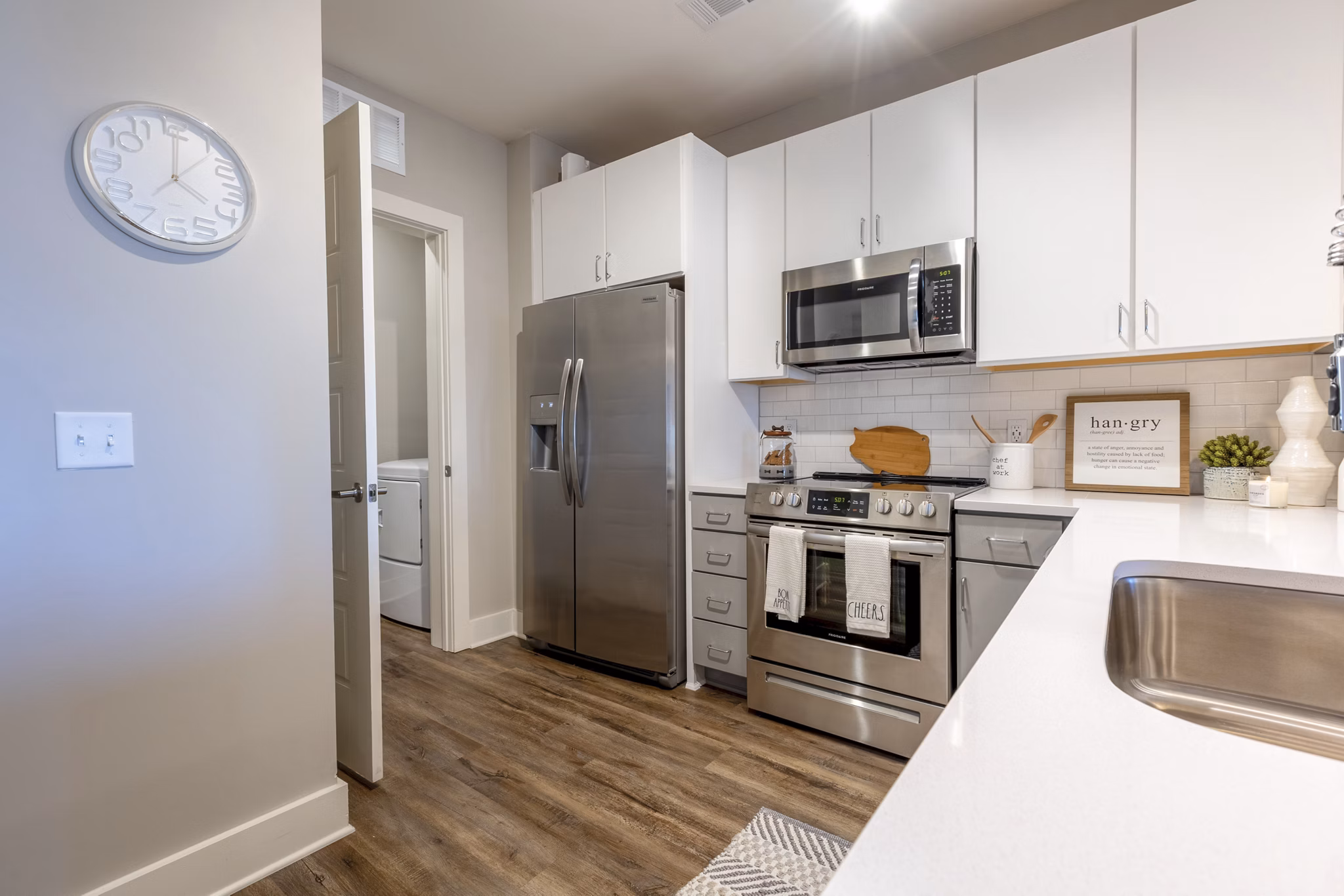 Modern kitchen with stainless steel appliances and island at Newbrook Point Hope Apartments, luxury living by Greystar