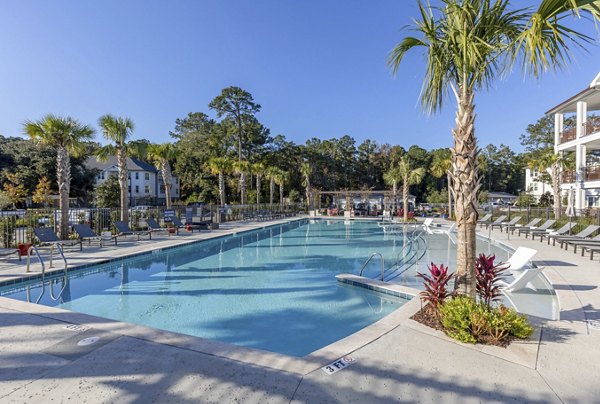 Outdoor pool with relaxing lounge area at Newbrook Point Hope Apartments