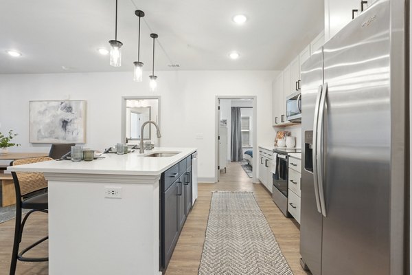 Modern kitchen with granite countertops and stainless steel appliances in Waterside at Pepper Hall Apartments