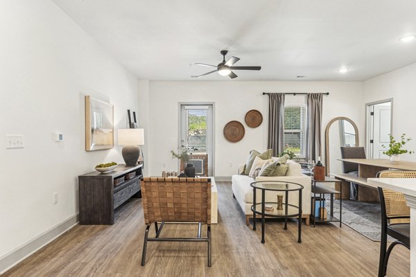 Elegant living room with stylish decor featuring cozy furniture and large windows at Waterside at Pepper Hall Apartments