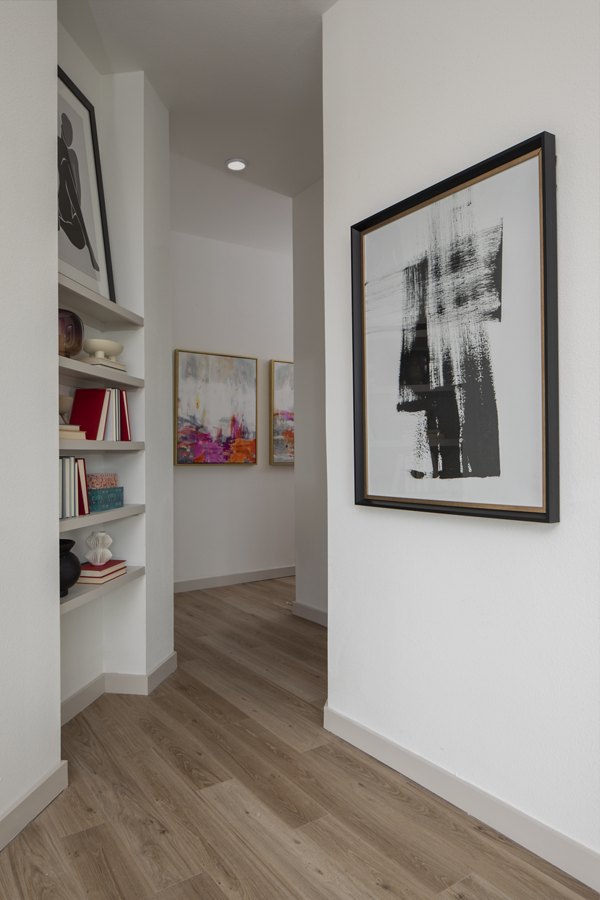 Hallway with modern lighting and artwork at Broadstone Frontera Ridge Apartments