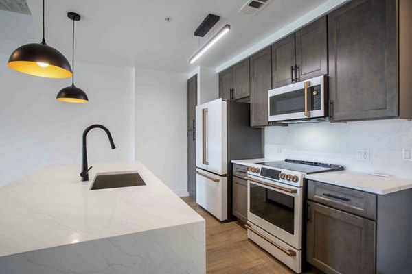 Modern kitchen with stainless steel appliances and granite countertops at Elliston 23 Apartments