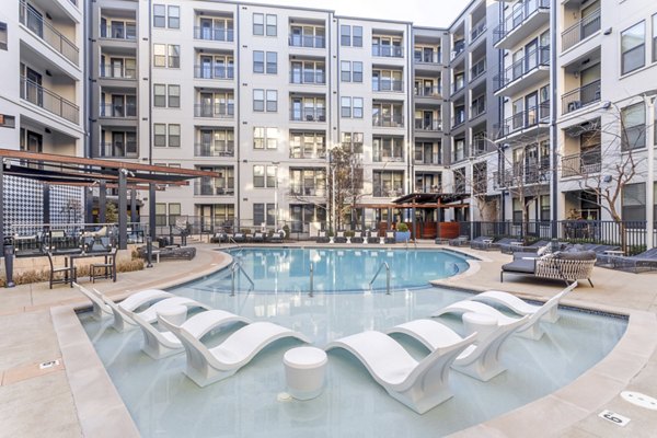 Modern swimming pool at Elliston 23 Apartments with luxurious lounge chairs and landscaping