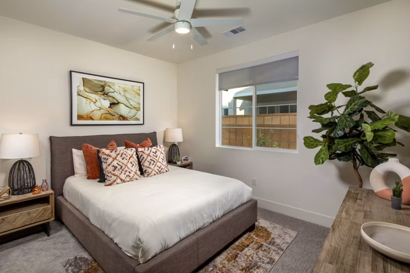 Cozy bedroom with modern decor and ample sunlight at SolTerra Apartments, luxury living in a serene setting