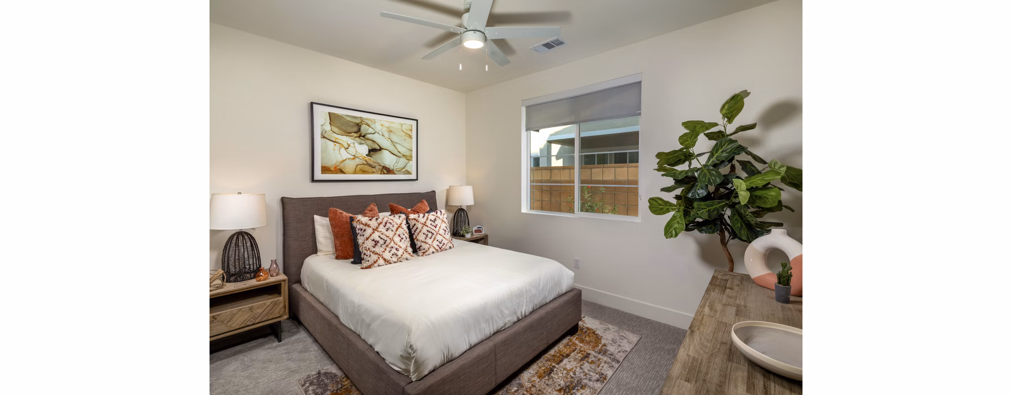 Cozy bedroom with modern decor and ample sunlight at SolTerra Apartments, luxury living in a serene setting