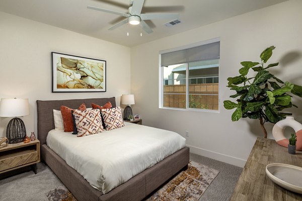 Cozy bedroom with modern decor and ample sunlight at SolTerra Apartments, luxury living in a serene setting