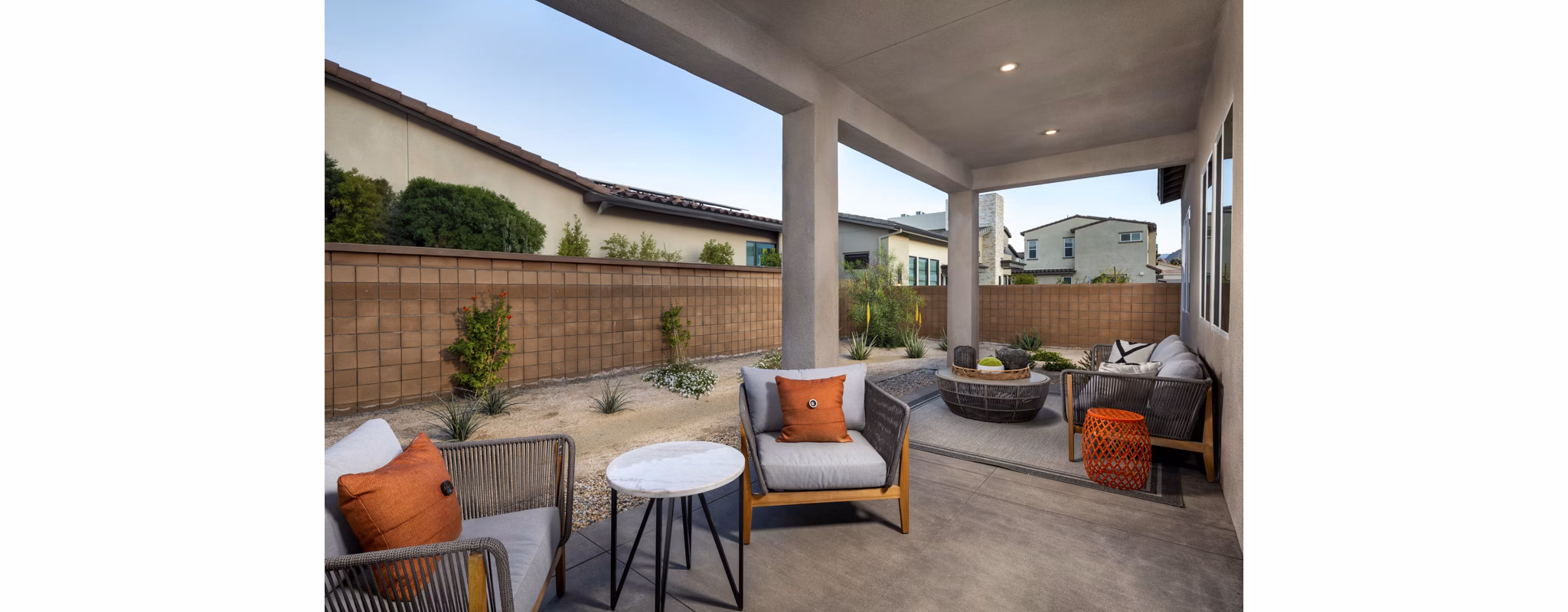 Elegant outdoor patio with modern seating at SolTerra Apartments, featuring lush greenery and ambient lighting for a relaxing atmosphere