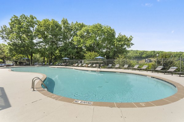 Resort-style pool with lounge chairs at Brentwood Oaks Apartments, offering a luxury living experience in a serene environment