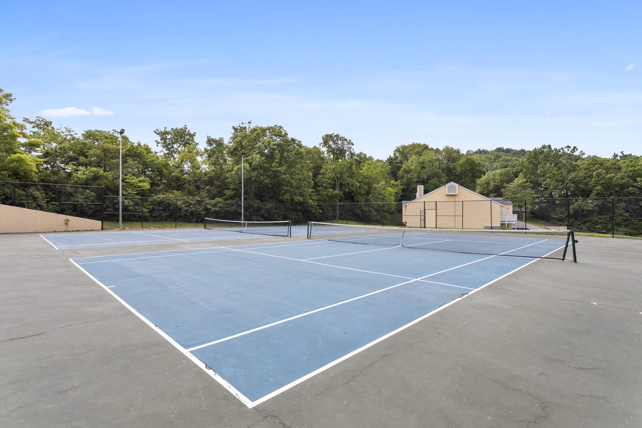 Outdoor sport court at Brentwood Oaks Apartments, featuring tennis and basketball facilities for active living