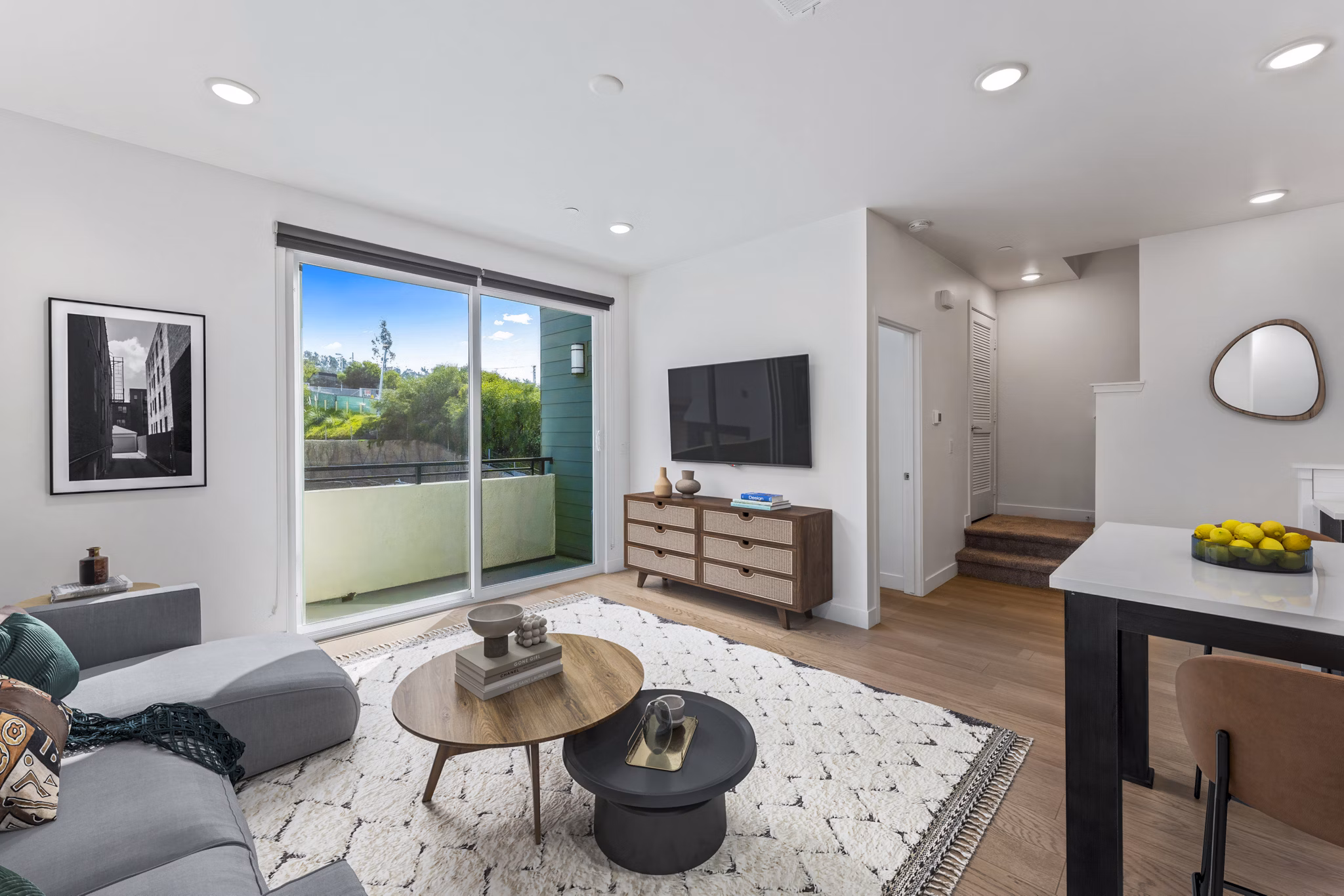 Living room with modern decor and large windows at Ascent at Campus of Life Apartments