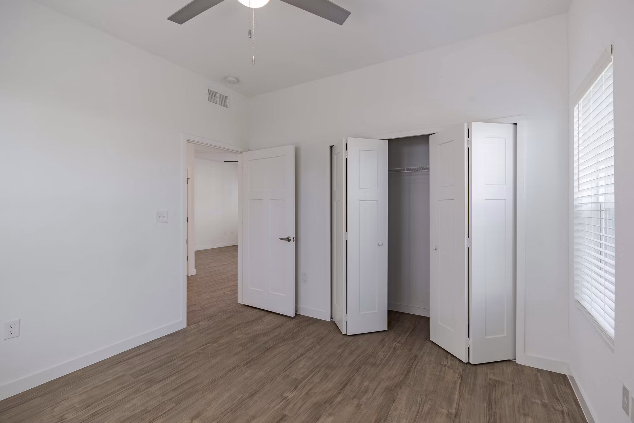 Bedroom with sleek modern design and large windows at Eden Magnolia Village Apartments