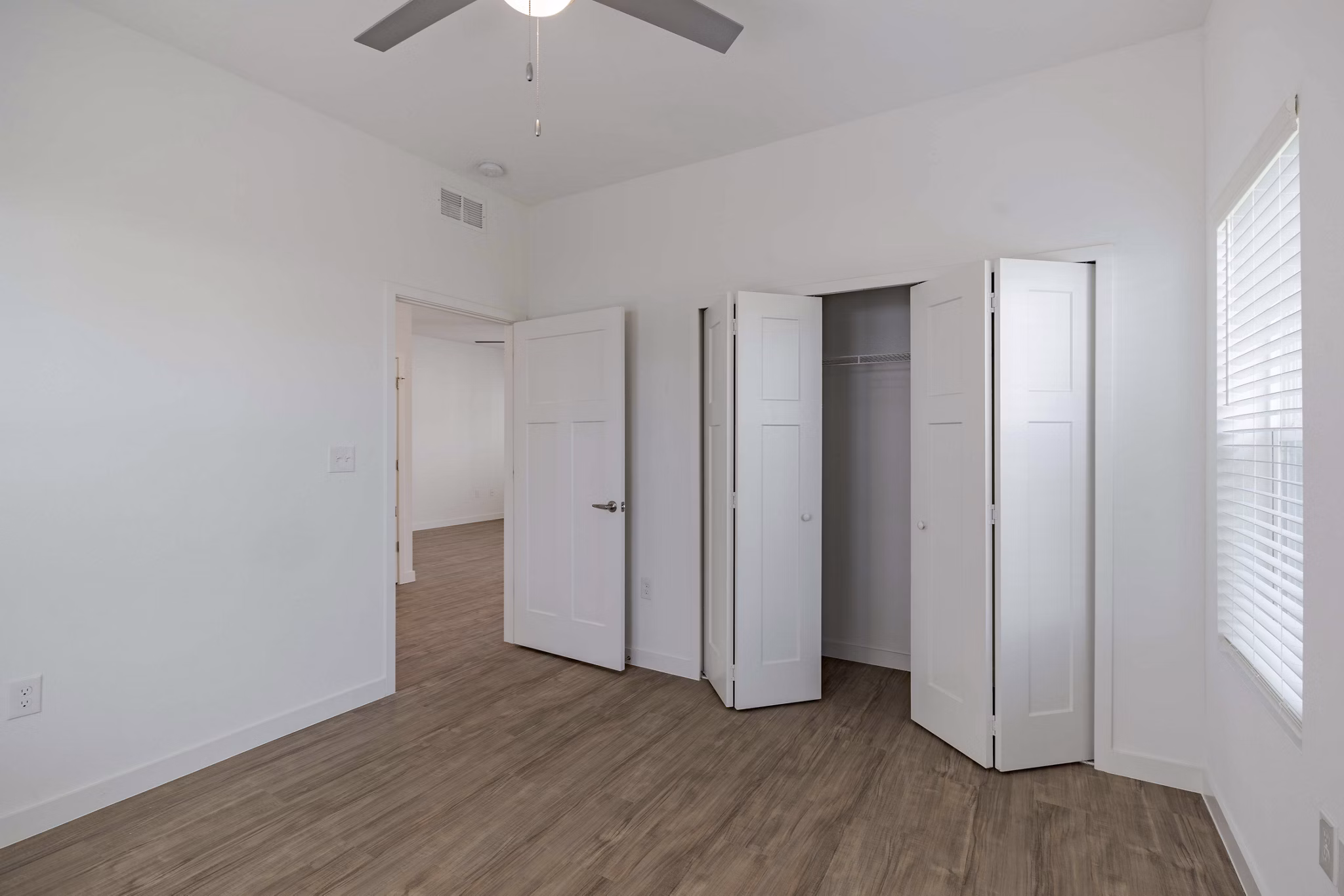 Bedroom with sleek modern design and large windows at Eden Magnolia Village Apartments