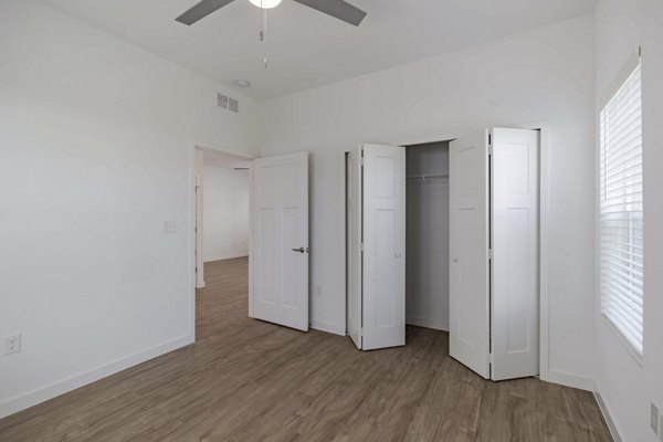 Bedroom with sleek modern design and large windows at Eden Magnolia Village Apartments