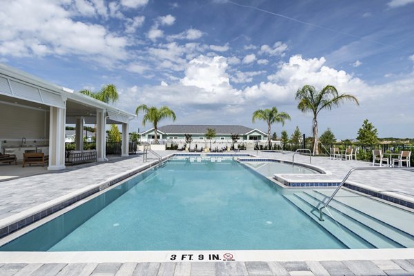 Swimming pool at Eden Magnolia Village Apartments with poolside seating