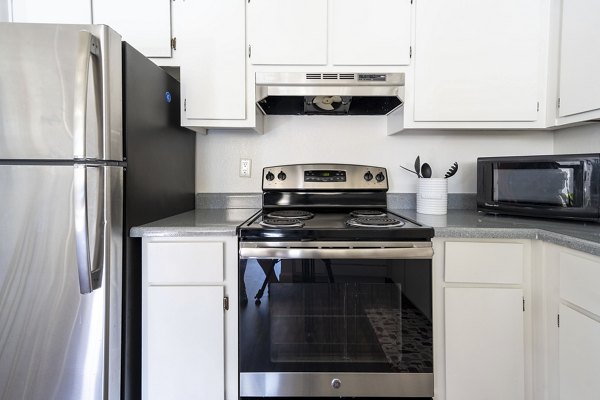Modern kitchen with stainless steel appliances and granite countertops at Sundance Apartments luxury living
