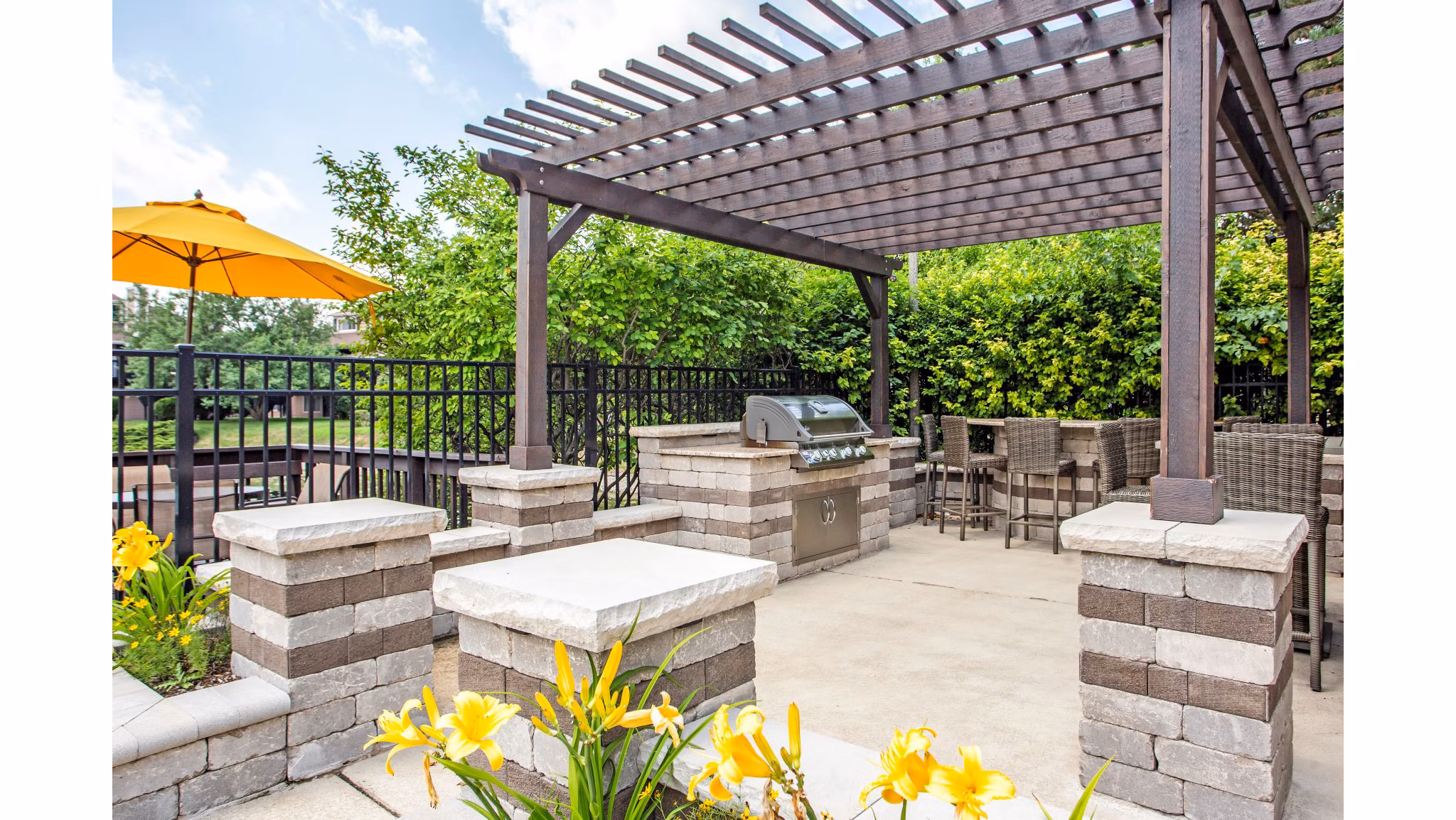 Outdoor grill area with seating at Haven on Long Grove Apartments, perfect for social gatherings and dining al fresco