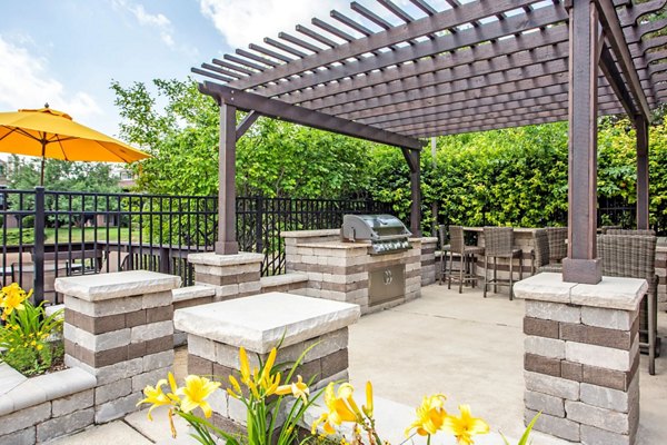 Outdoor grill area with seating at Haven on Long Grove Apartments, perfect for social gatherings and dining al fresco
