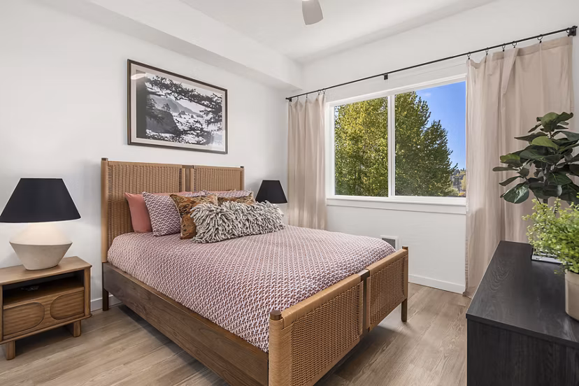 Cozy bedroom with modern decor at Prose Kent Station Apartments featuring plush bedding and ambient lighting