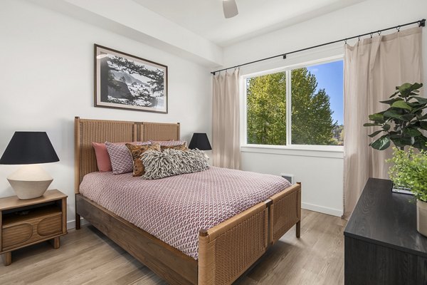 Cozy bedroom with modern decor at Prose Kent Station Apartments featuring plush bedding and ambient lighting