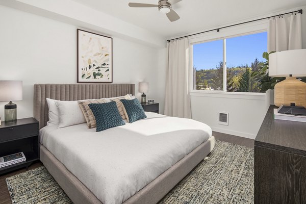 Cozy bedroom with modern decor at Prose Kent Station Apartments, featuring natural light and ample space for relaxation