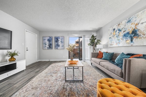 Cozy living room with modern decor at Sierra Pines Apartments, featuring natural light and spacious design for luxury living