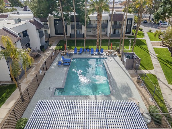 Outdoor pool with lounge chairs at Sierra Pines Apartments, ideal for relaxation and leisure, offering a luxury experience and community social space