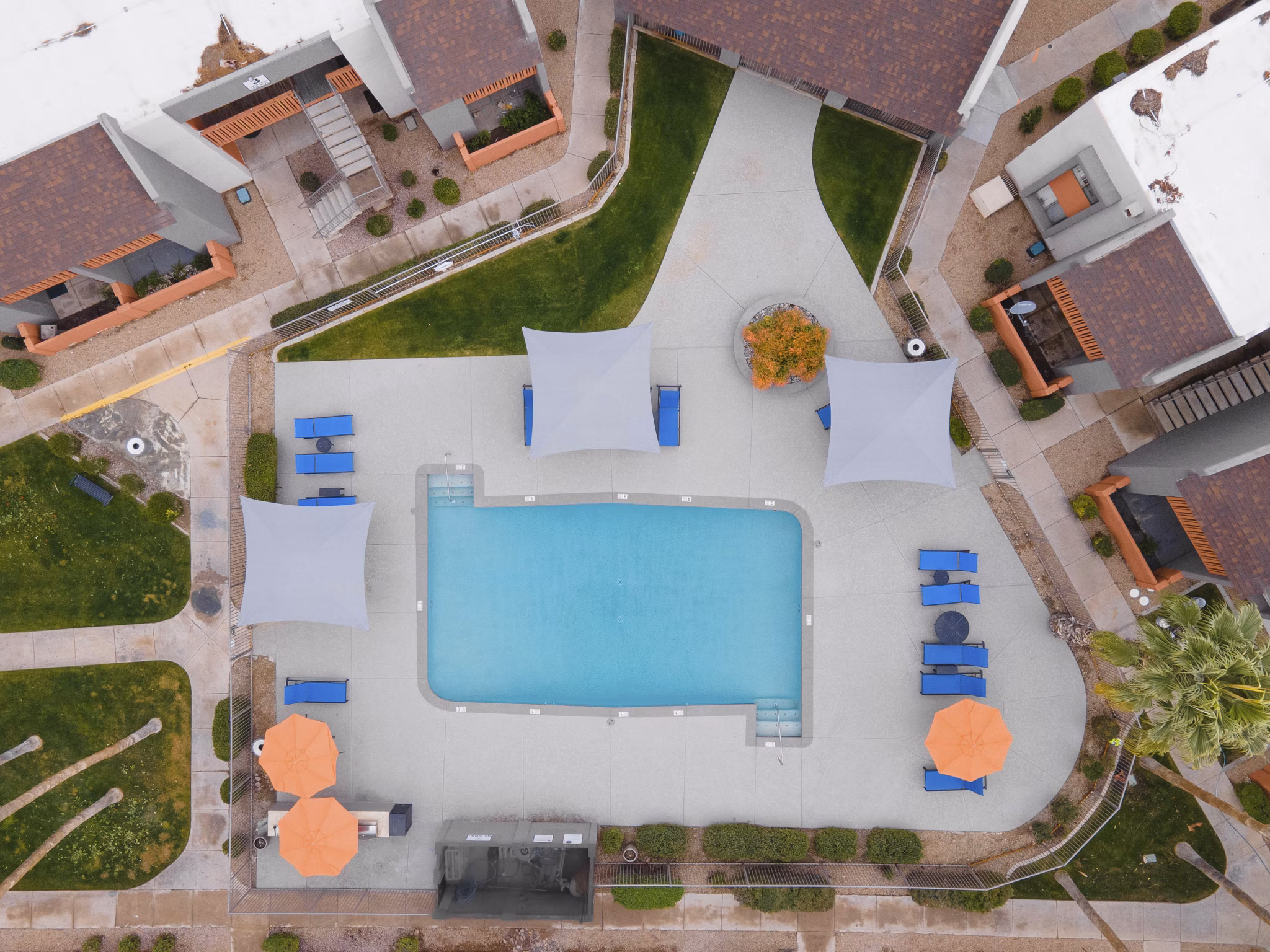 Resort-style pool with shaded lounge areas at Sierra Pines Apartments, offering luxury living in a serene setting