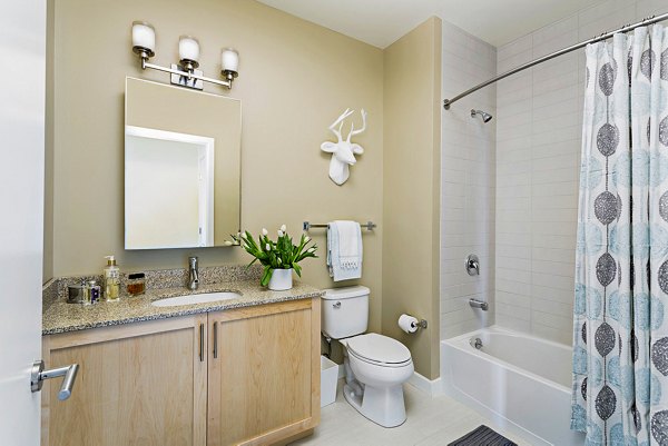 Bathroom featuring sleek fixtures and contemporary design at Flats on D Apartments
