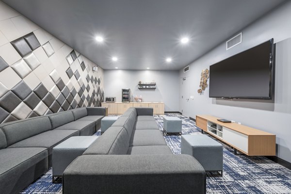 Clubhouse theater with plush seating and large screen at Flats on D Apartments