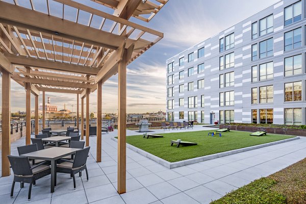 Spacious patio with modern seating and greenery at Flats on D Apartments, perfect for outdoor recreation and relaxation