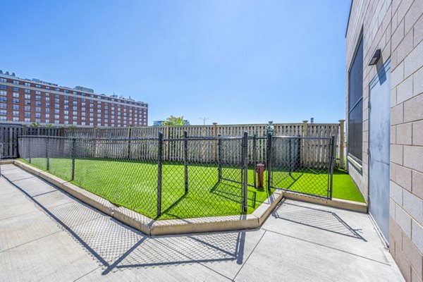 Off-leash dog park at Flats on D Apartments, featuring agility equipment and open play areas for pets