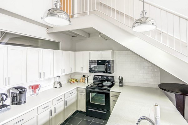 Modern kitchen with stainless steel appliances at Heinz Lofts Apartments, luxury living by Greystar in urban setting