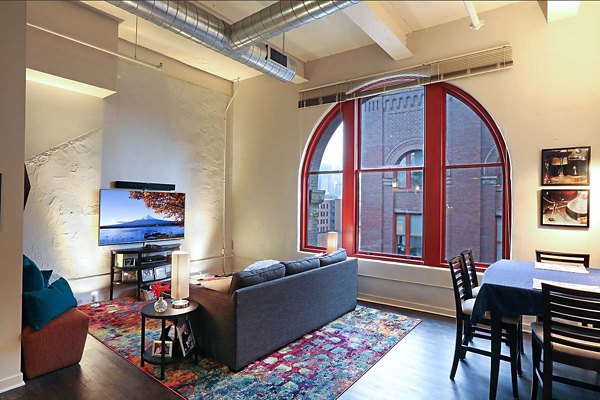 Spacious living room with modern decor and large windows in Heinz Lofts Apartments