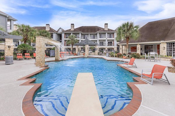 Resort-style pool with lounge chairs at City Park in The Heights Apartments