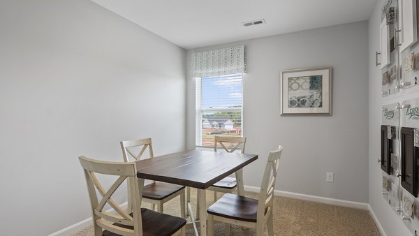 Dining area featuring modern lighting and sleek furniture in Rosemary Glen Apartments