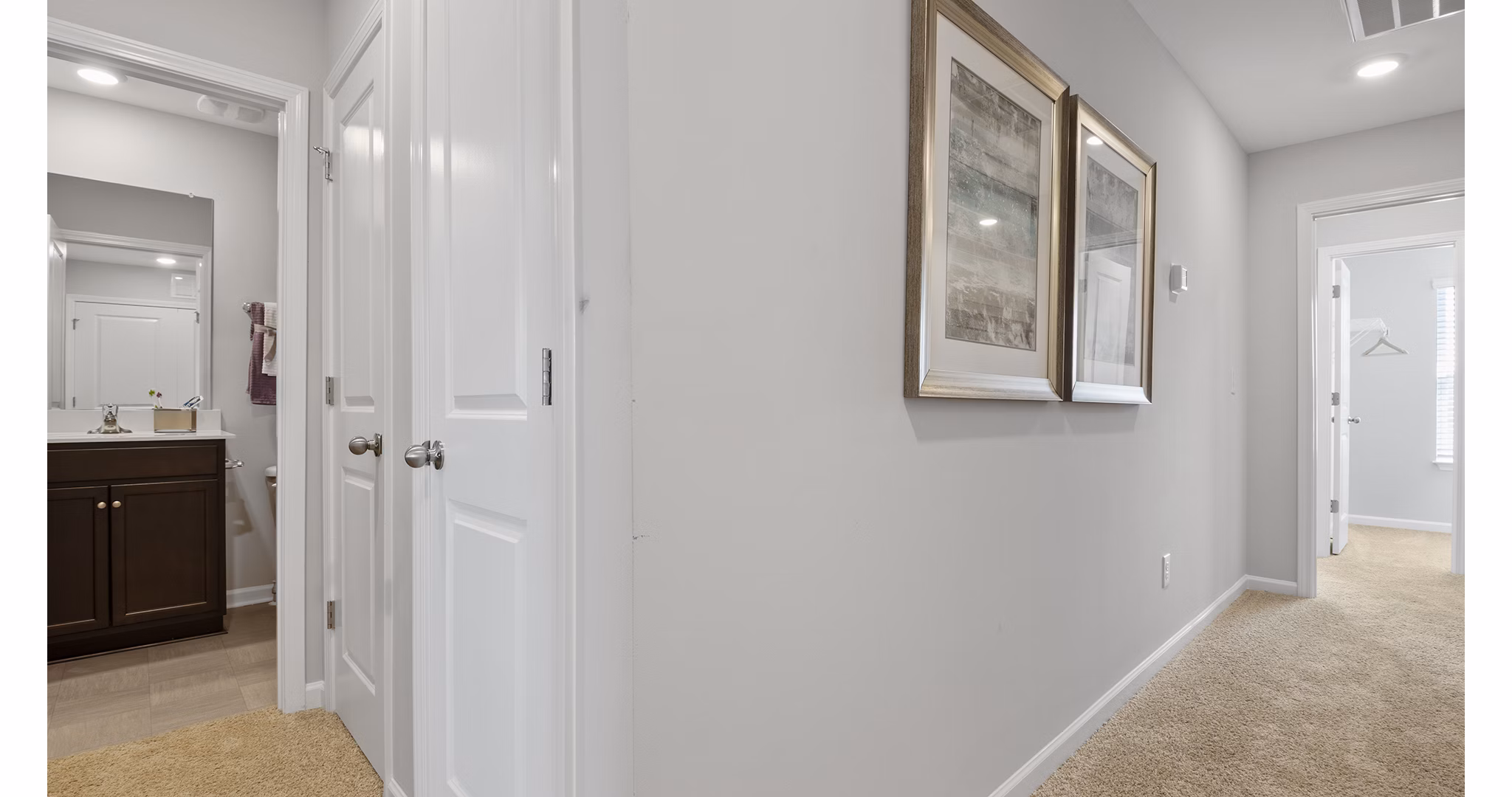 Hallway with contemporary lighting and artwork at Rosemary Glen Apartments, luxury apartments by Greystar