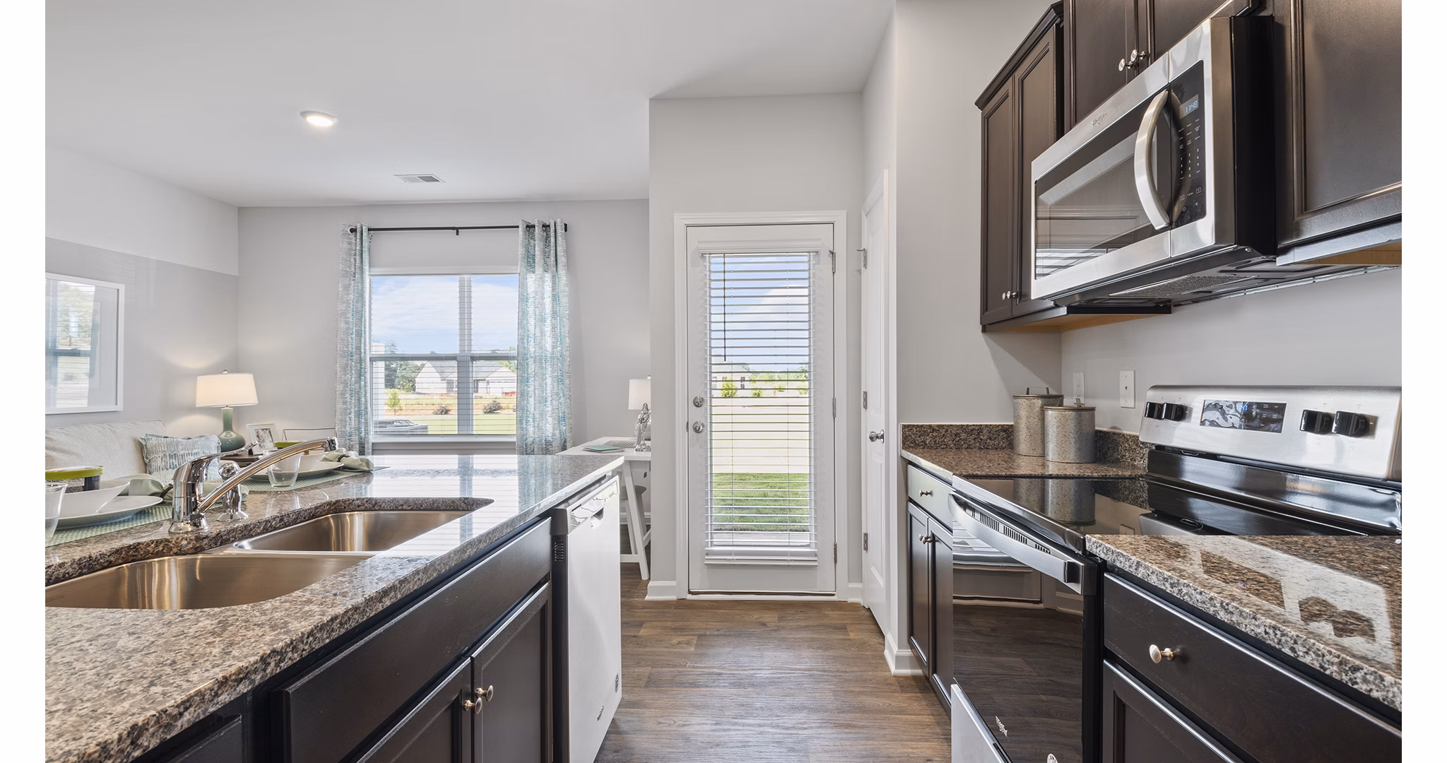 Modern kitchen with stainless steel appliances and granite countertops at Rosemary Glen Apartments