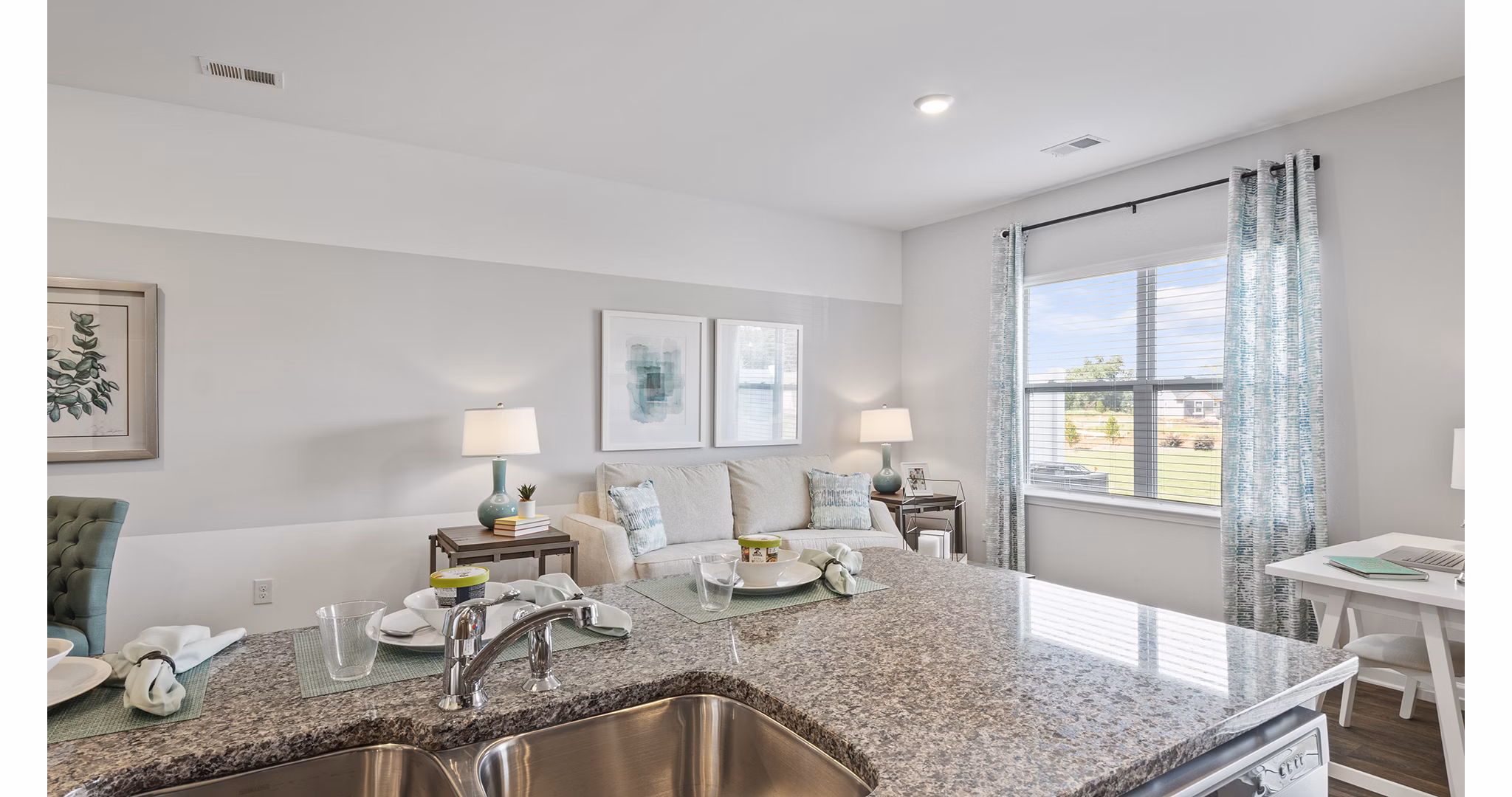 Modern kitchen featuring stainless steel appliances and granite countertops in Rosemary Glen Apartments