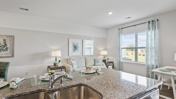 Modern kitchen featuring stainless steel appliances and granite countertops in Rosemary Glen Apartments
