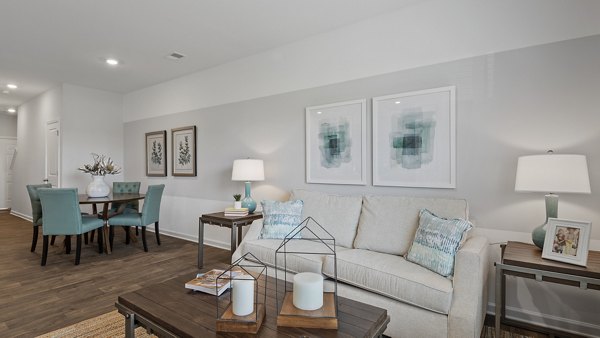 Modern living room featuring plush seating and large windows at Rosemary Glen Apartments