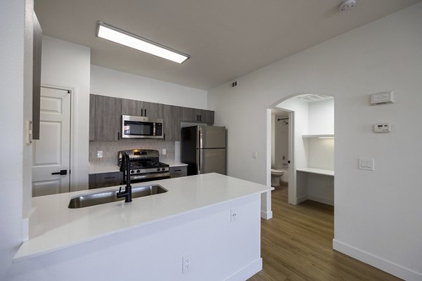 Modern kitchen with sleek countertops and stainless steel appliances in Cyan at Green Valley Apartments