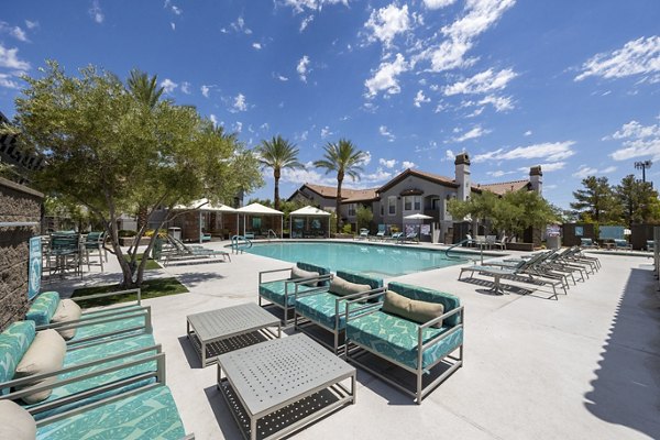 Luxurious poolside view at Cyan at Green Valley Apartments with modern lounge chairs and lush landscaping