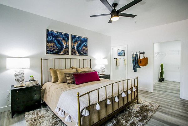 Bedroom with modern decor and large window at The Presley at Whitney Ranch Apartments